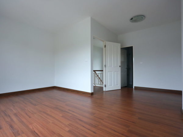 interior design empty room with white wall and wooden laminate floor in new residential house